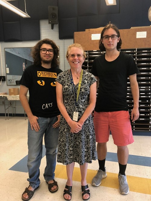 Two students and a teacher pose for a photo