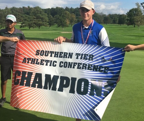 Student holds banner reading "Southern Tier Athletic Conference Championship"